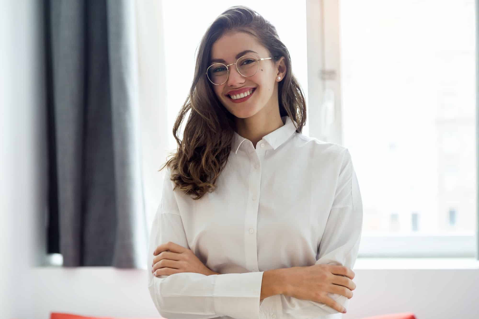 Beautiful smiling businesswoman with eyeglasses looking at the c