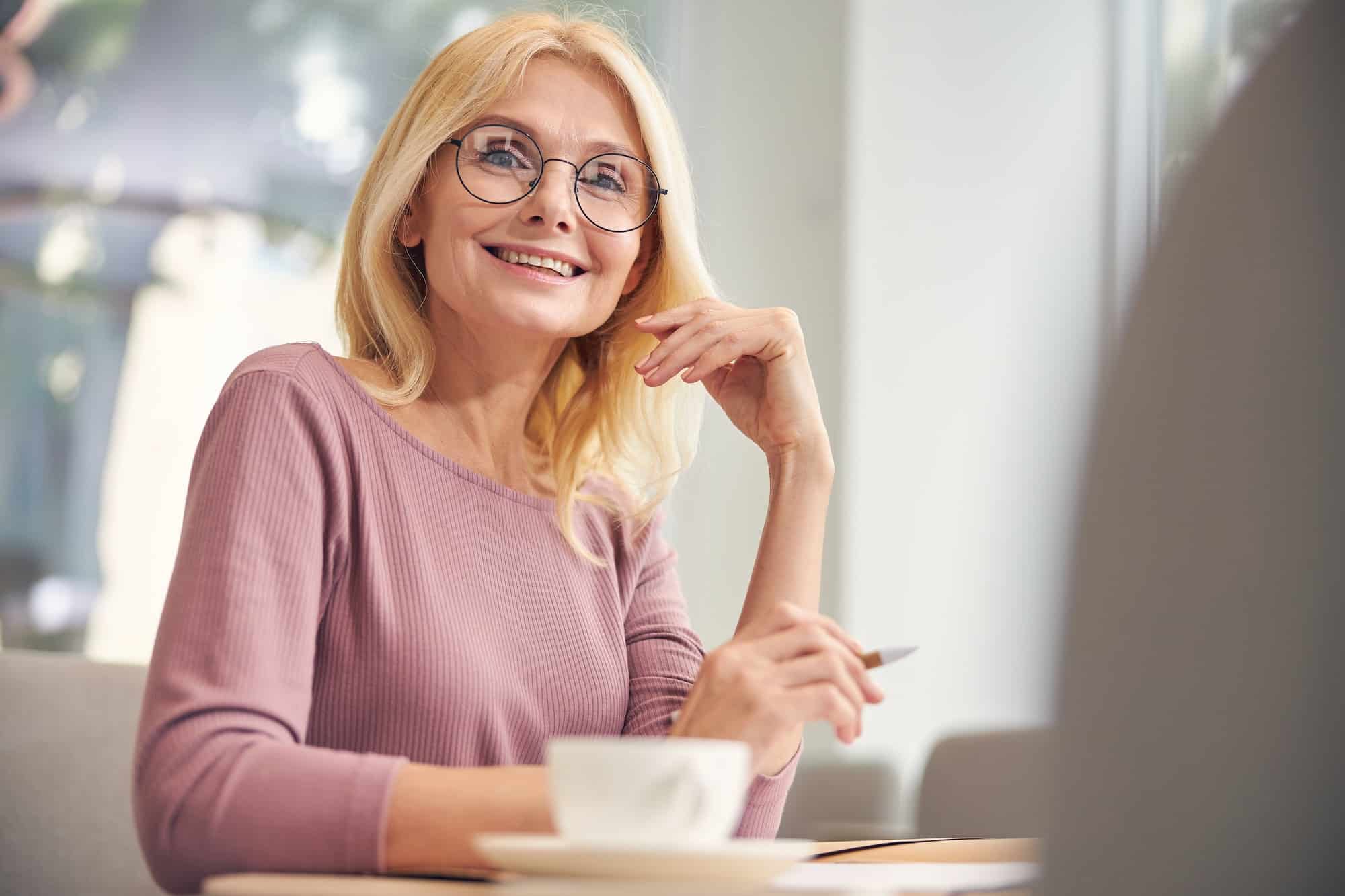 Positive delighted mature woman looking at camera
