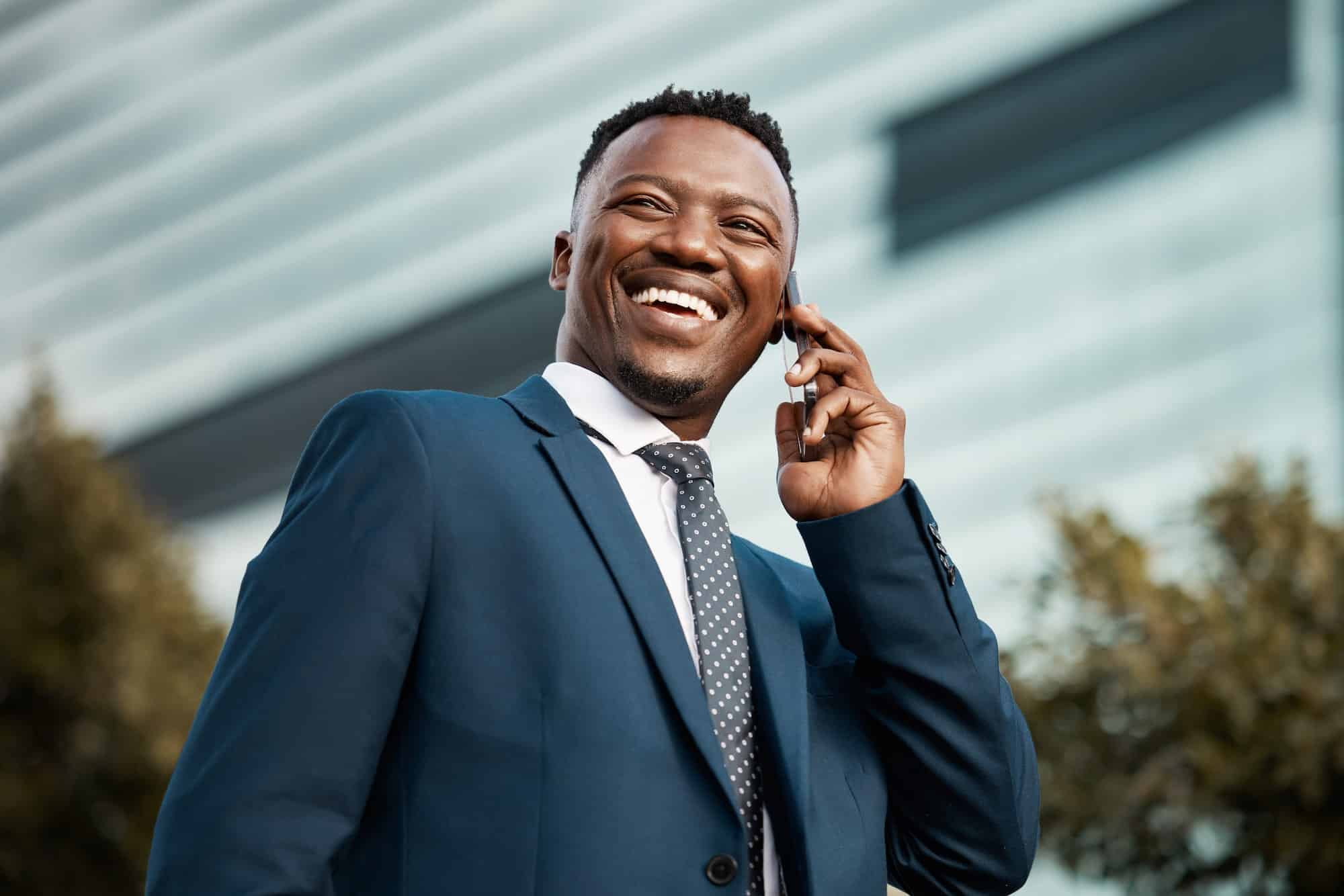 Shot of a handsome young businessman using his smartphone to make a phone call